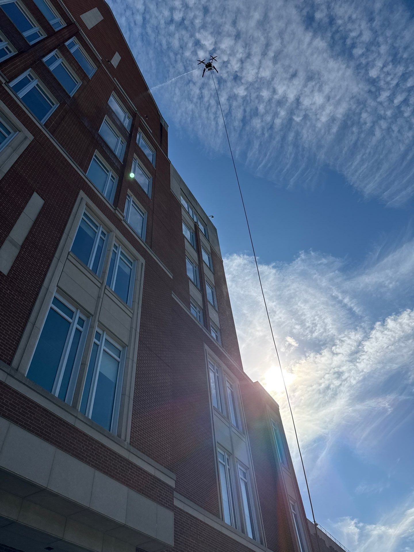 Drone cleaning high windows on a commercial building